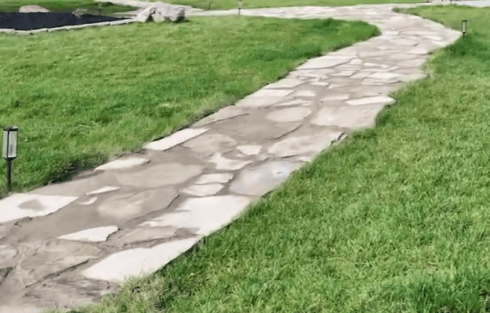 Stone pathway through lush green lawn at Rimrock Montana leading provider of addiction treatment and behavioral health services in Montana.